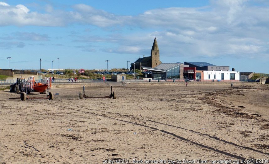 Back across the bay At Newbiggin-By-The-Sea, St Bartholomew's and The Maritime centre in the view